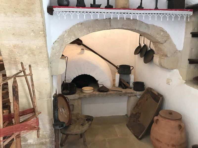 a traditional wood-stove in Crete with many old kitchen utensils around