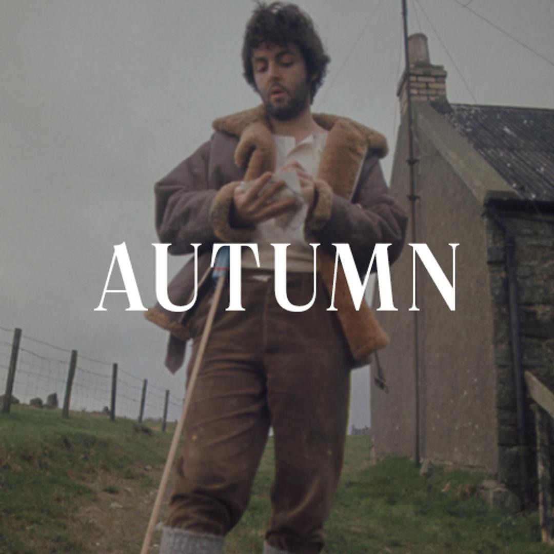 Paul McCartney standing on a farm surrounded by green fields and countryside scenery, with the word "Autumn" displayed across the top of the image.