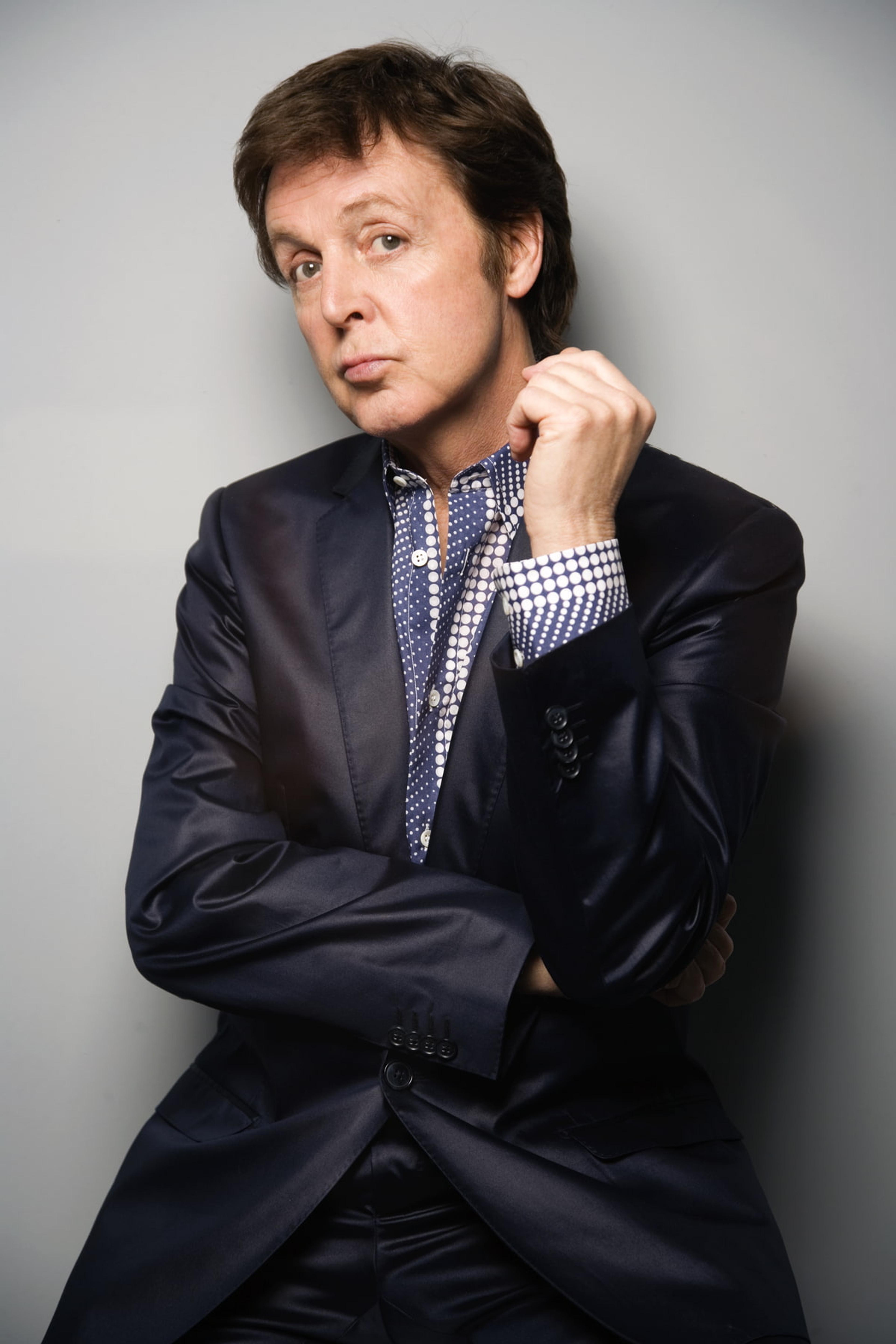 Paul wearing a suit and sitting with his hands folded
