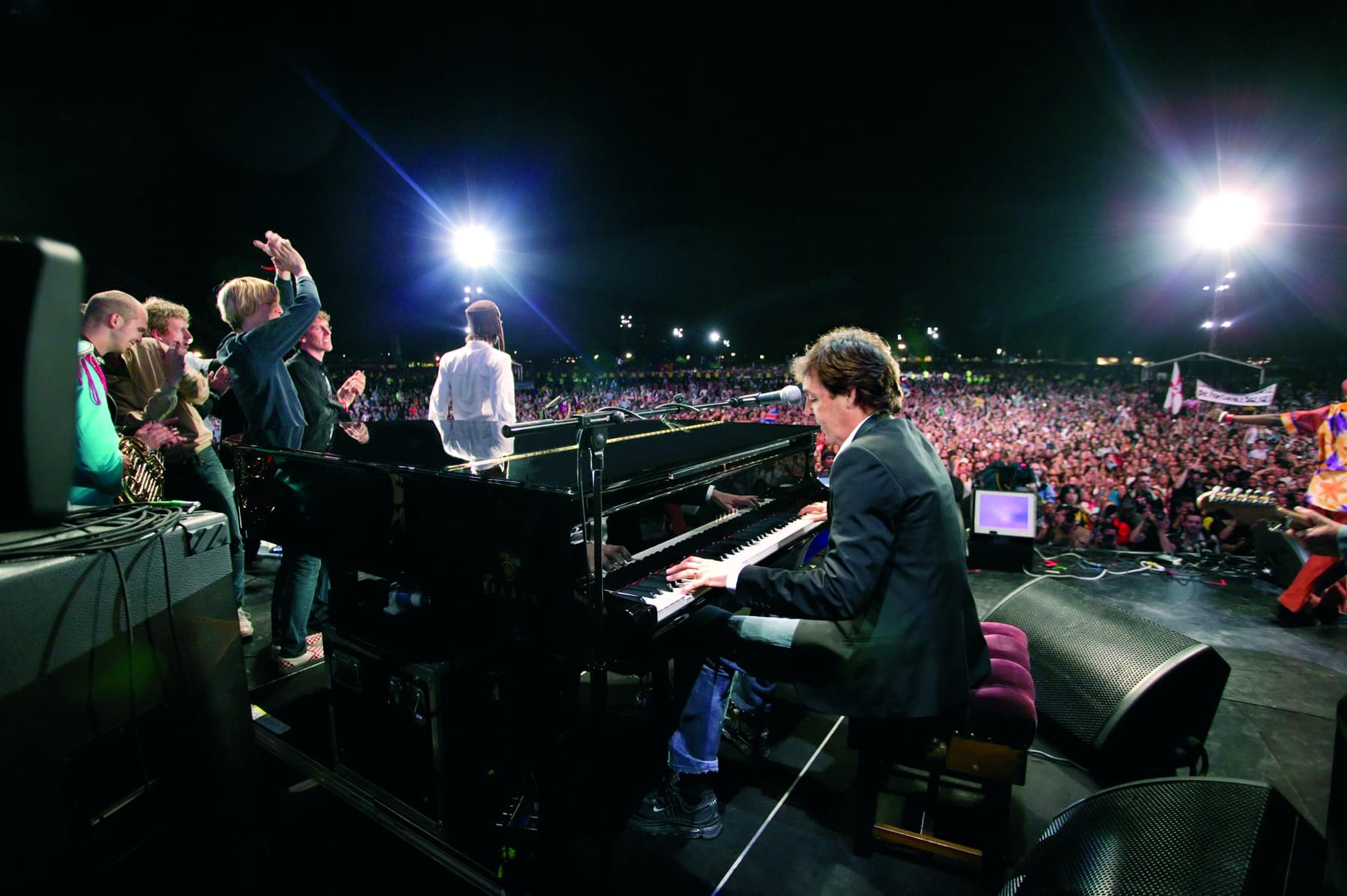 Paul sat at a piano on stage with a group of other Live 8 artists