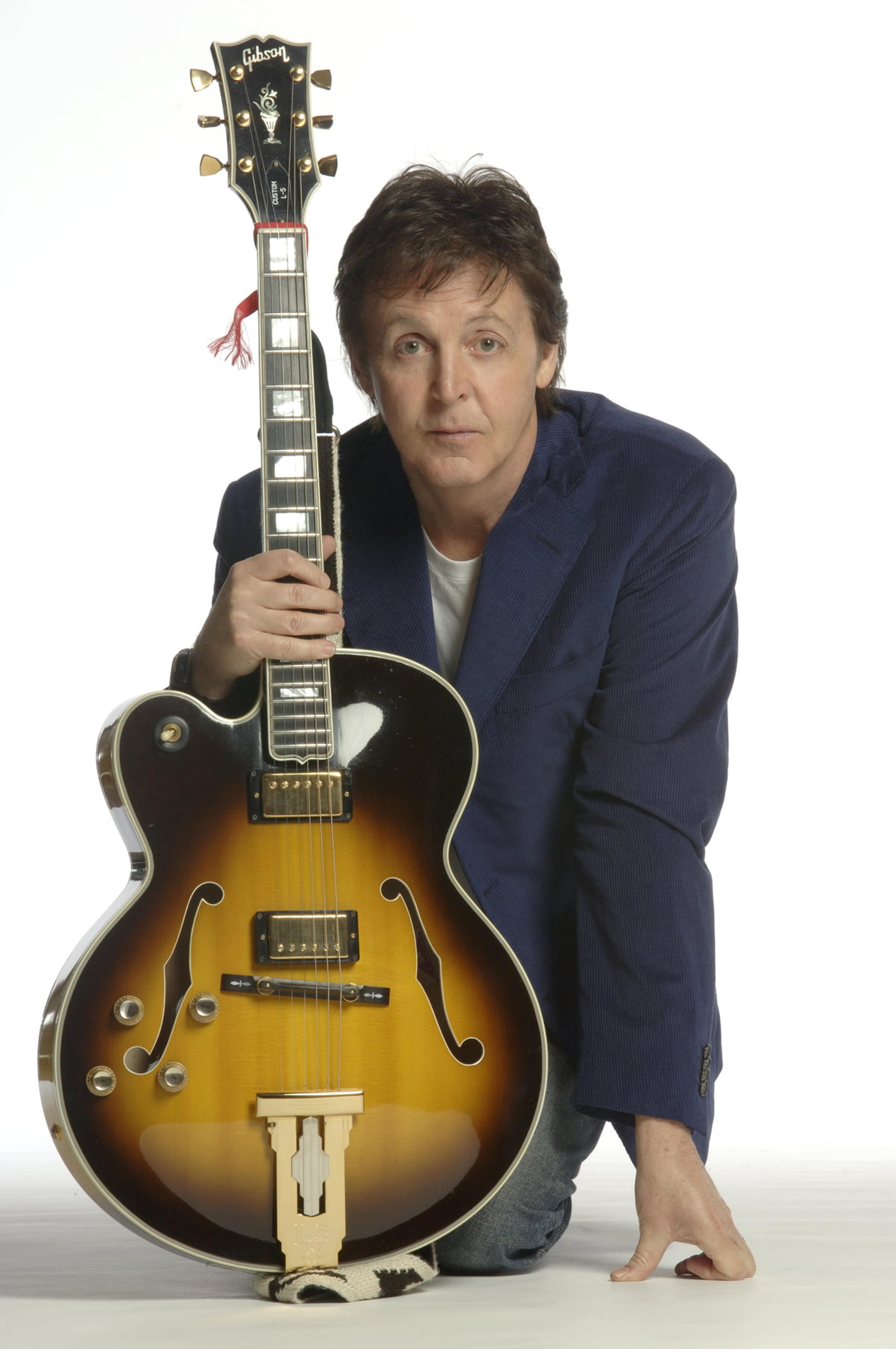 Paul sitting down holding a guitar