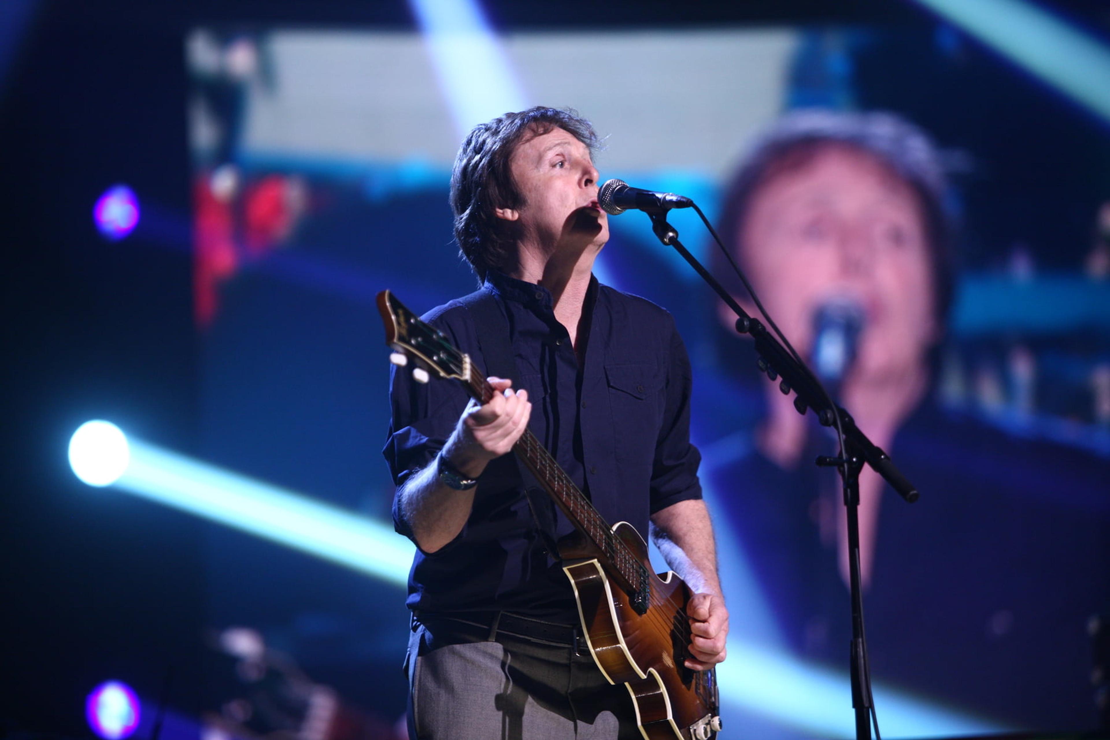 Paul standing on stage playing the bass guitar