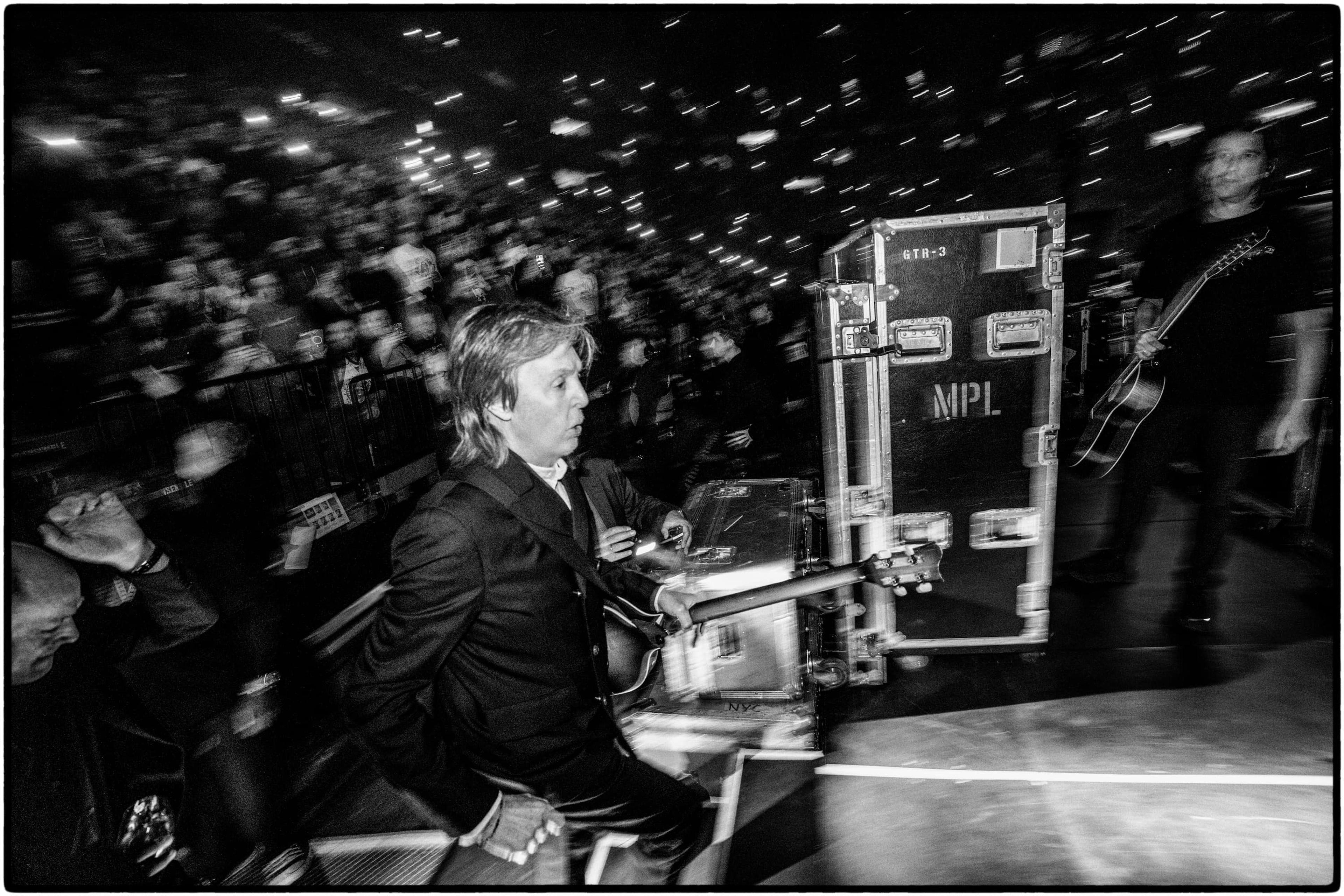 Black and white photograph of Paul McCartney with motion blur as he runs toward the stage for his show at Montreal’s Bell Centre during the 2025 “Got Back” tour.