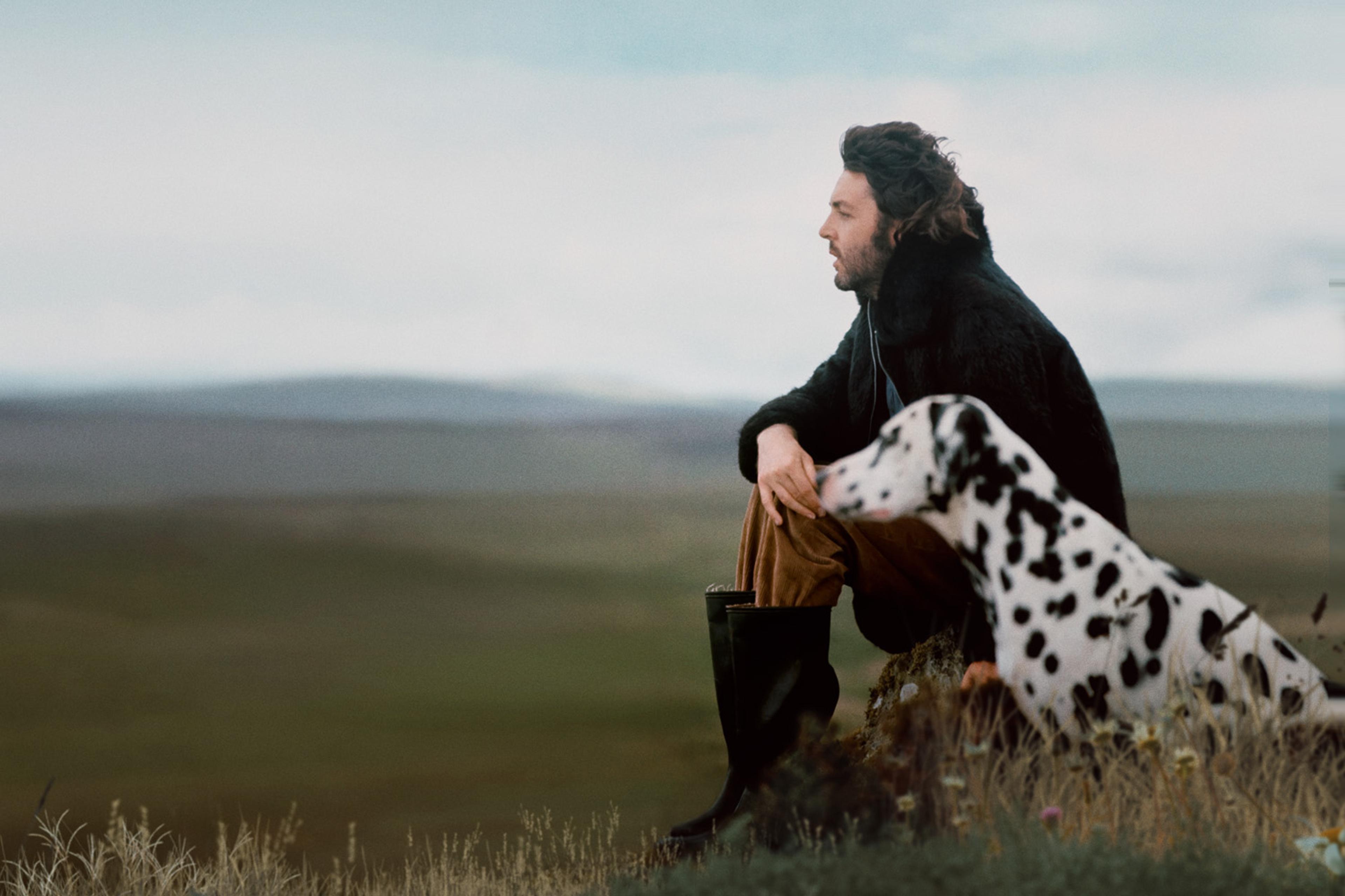 Portrait photograph of Paul McCartney with his dog in a field in Scotland 