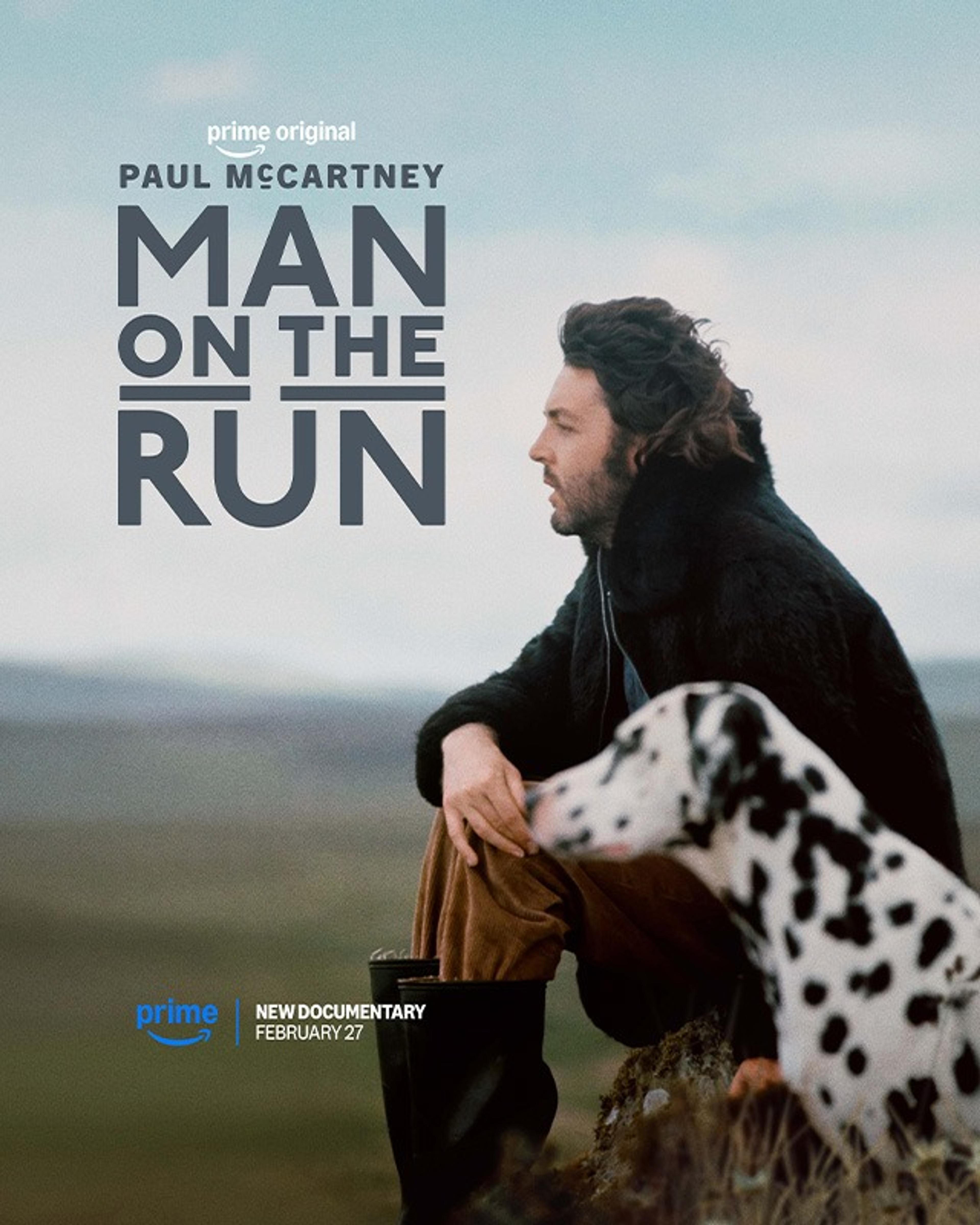 Portrait photograph of Paul McCartney with his dog in a field in Scotland. Including the text for the film Paul McCartney:Man on the Run 