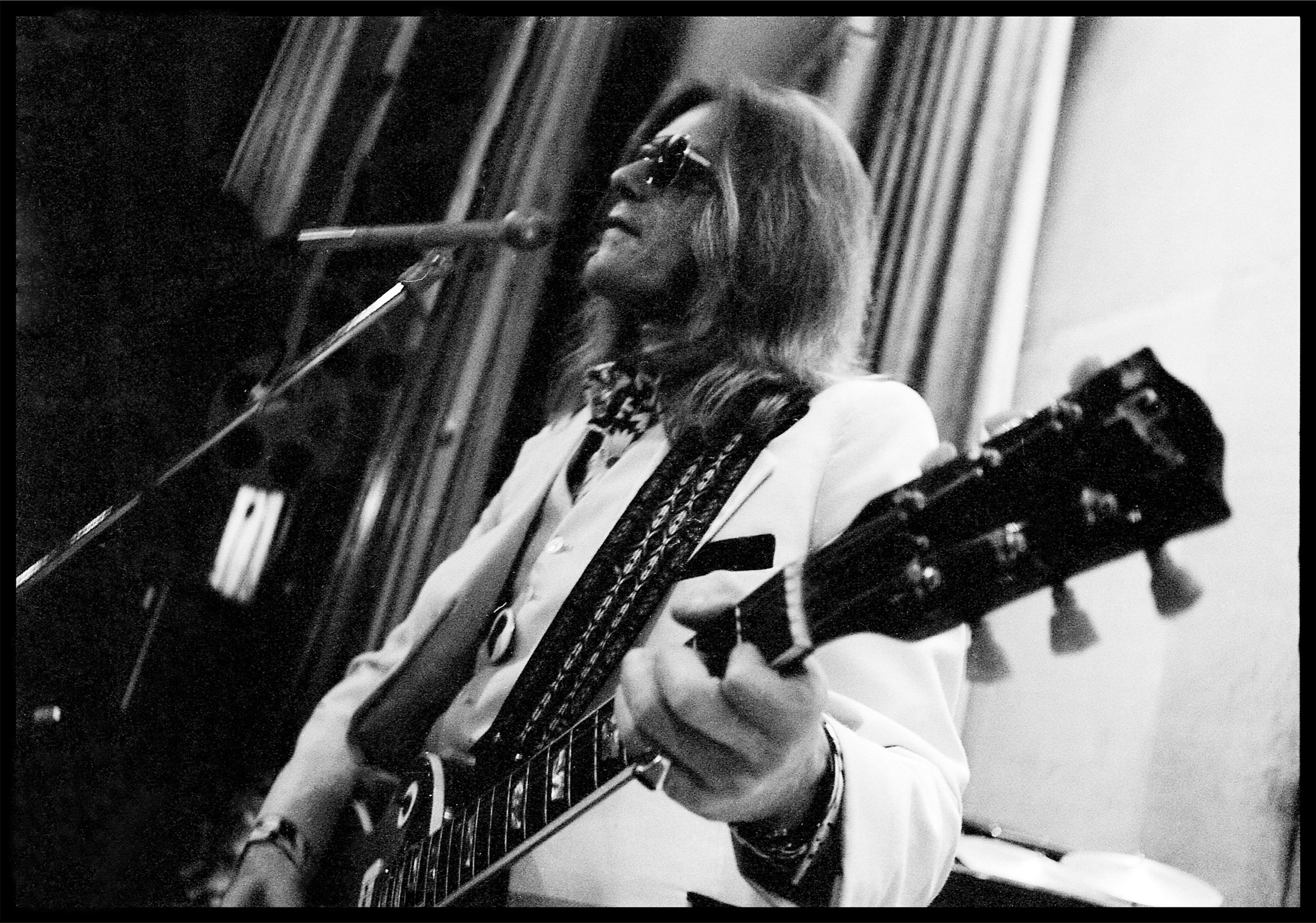 Black and white photograph of Henry McCullough playing on stage