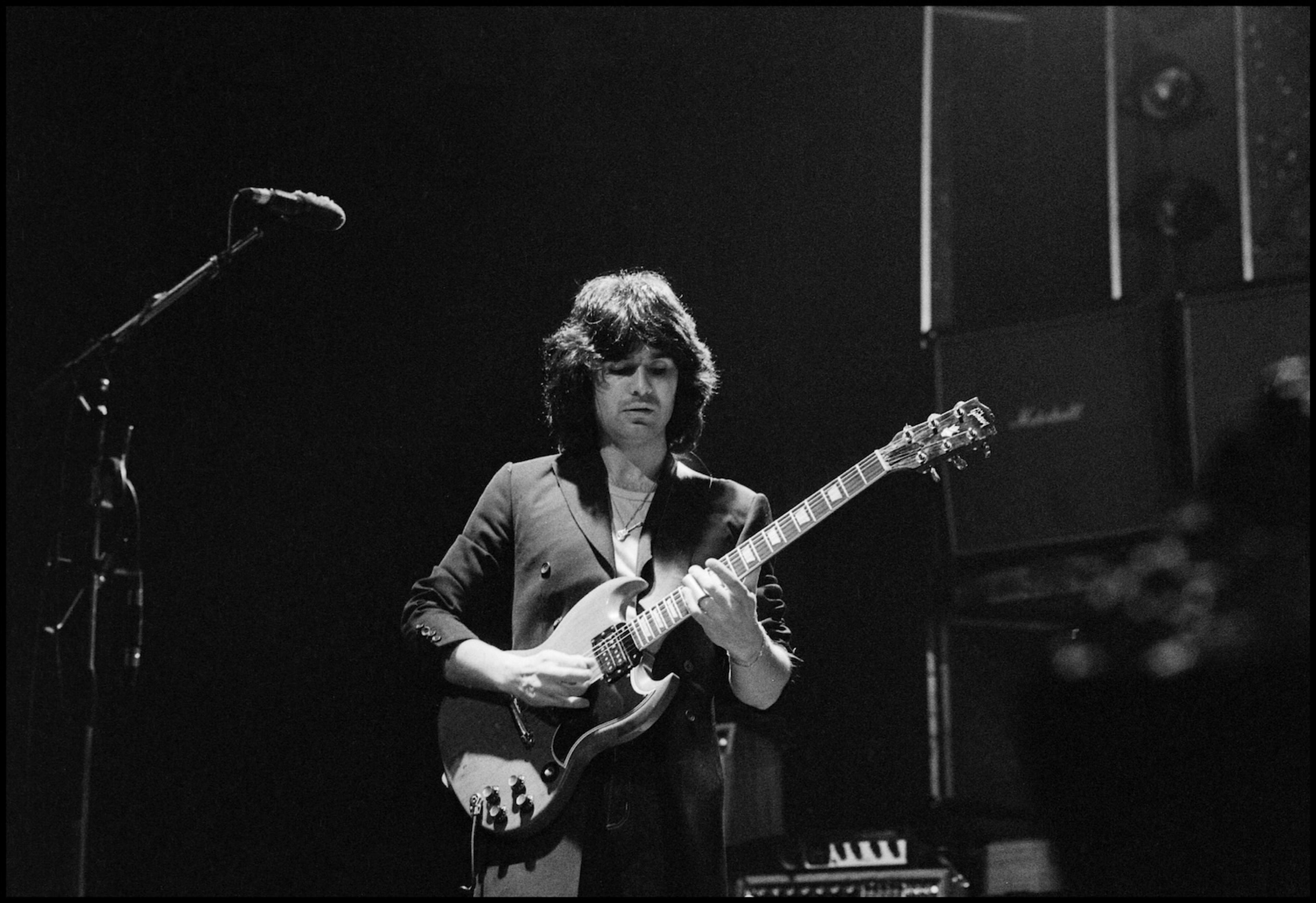 Black and white photograph of Laurence Juber on stage