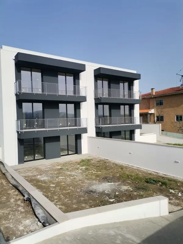 traseiras de casas geminadas, com terraço e jardim e arquitectura moderna em tons de preto e branco