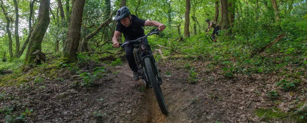 MTB rider on Cannondale Moterra e-bike riding in the woods with a black T-Shirt