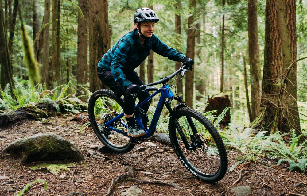 woman riding a Norco mountain bike inthe woods