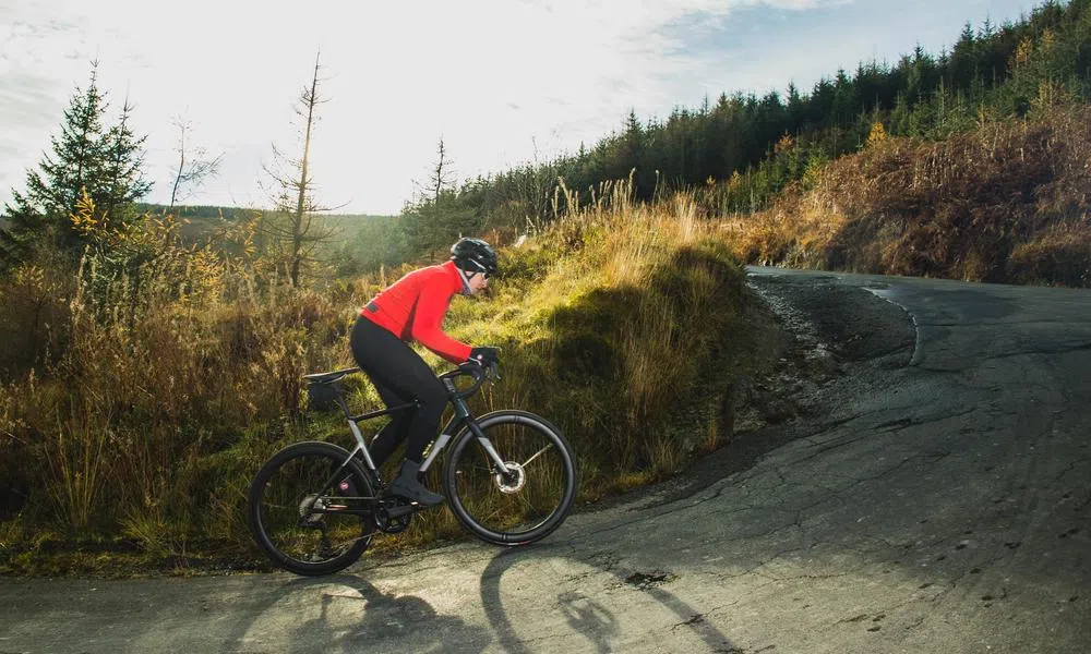 Road cyclist riding a steep uphill corner on a Cannondale evo on a sunny winter day 