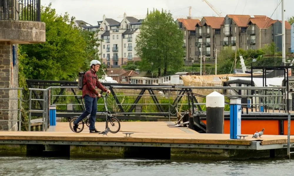 man with Brompton pushing bike to boat