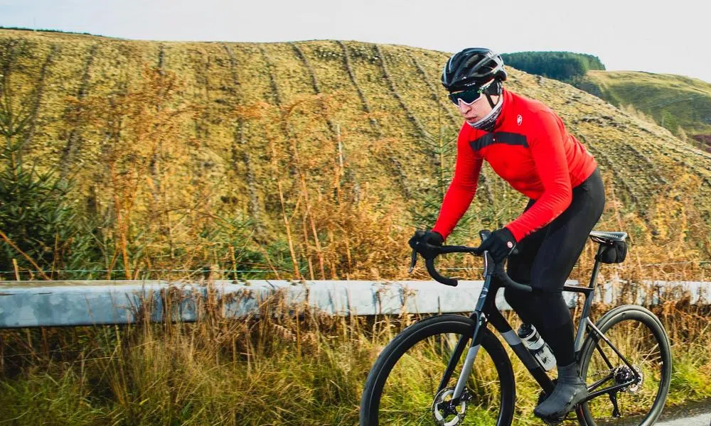 Road rider cycling up hill