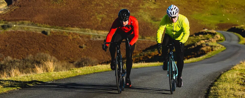 two cyclists riding in the winter sun