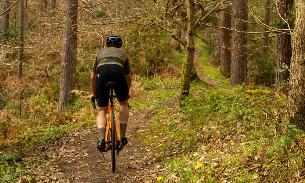 Gravel rider on singletrack in the woods