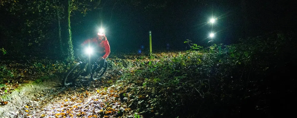 MTB night riders with front bar and helmet lights