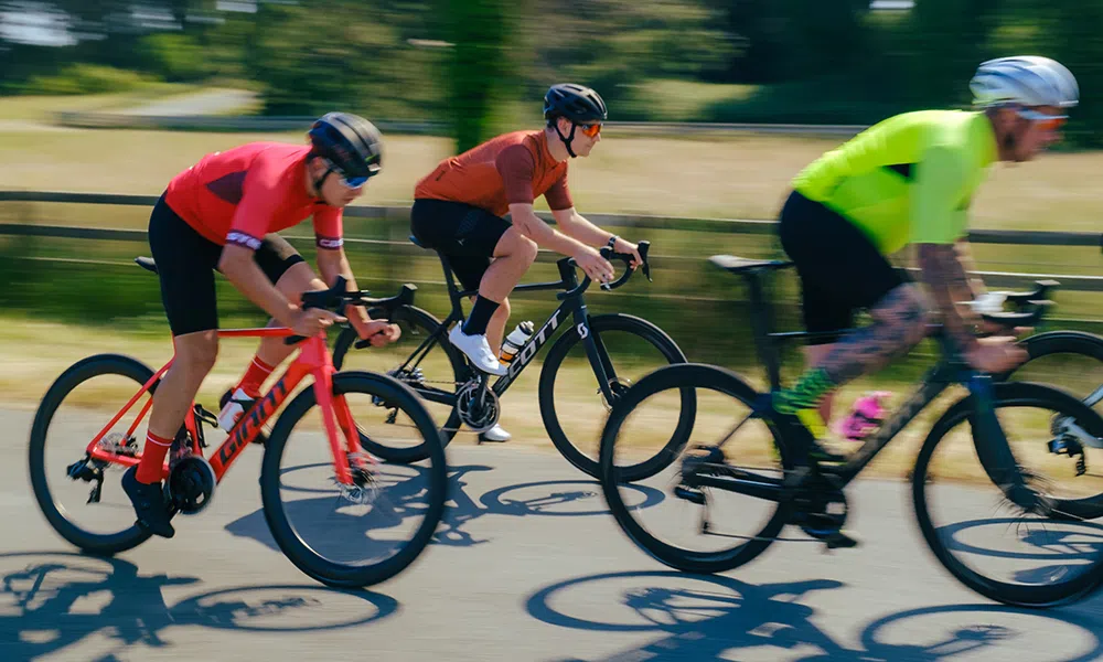 A group of road bikes ride past at speed