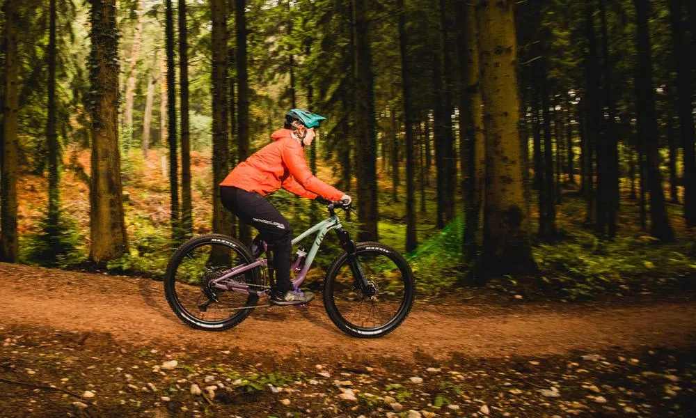 MTB rider descending through woods on a liv