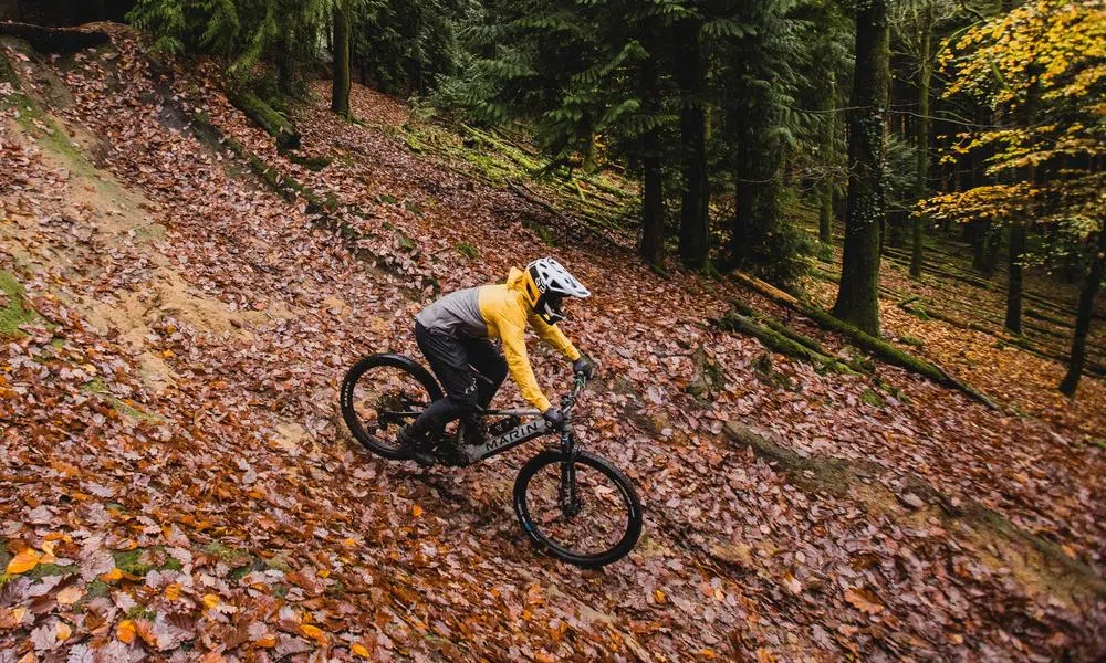 MTB rider descending through leaves