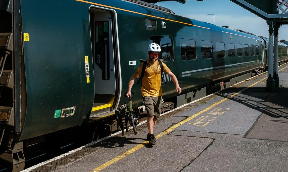 cyclist carrying brompton off train commuting