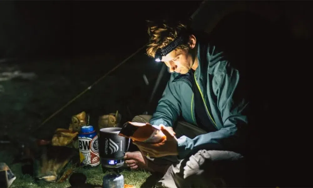 man camping at night with head torch