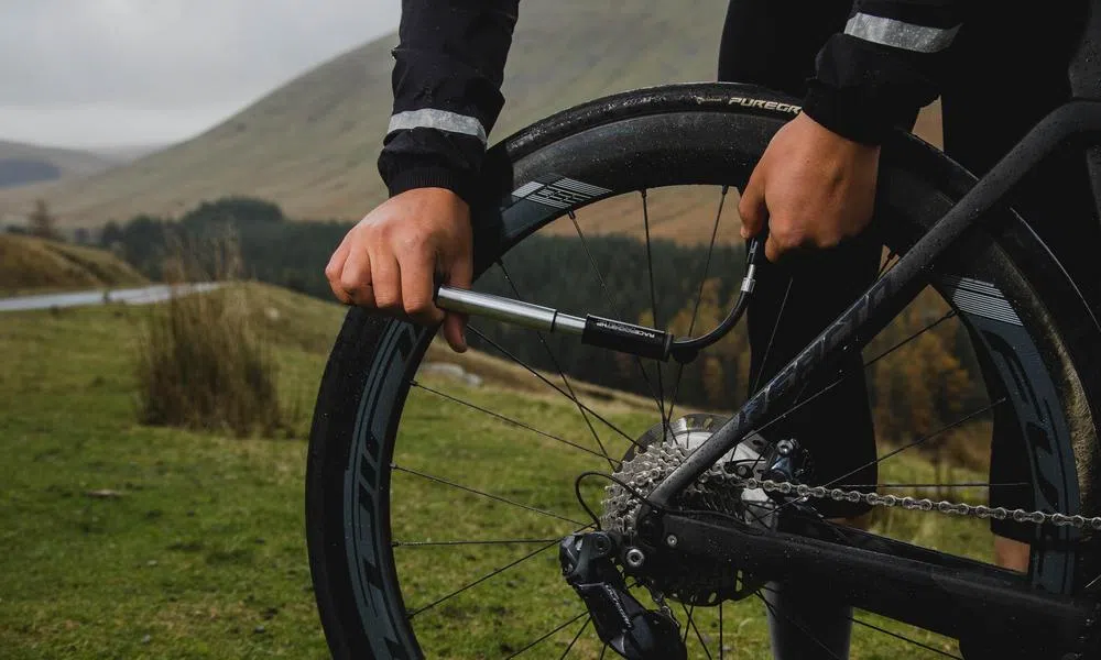 pumping up a road bike tyre with a small hand pump