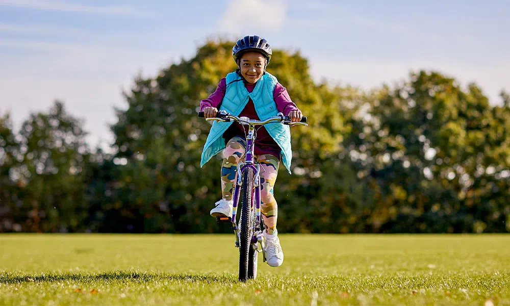 girl riding a kids bike in the park