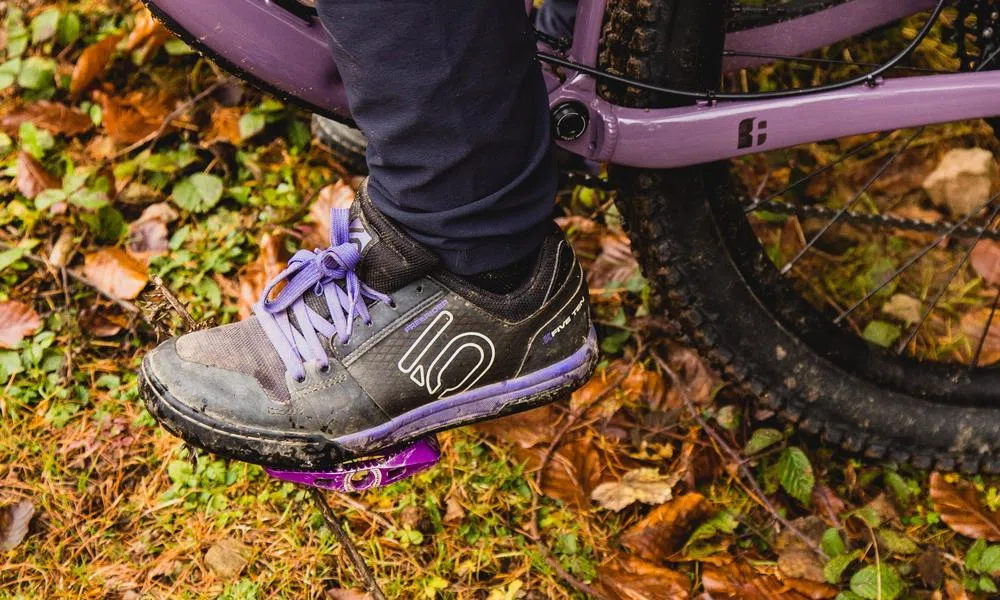 Purple women's Five Ten shoe with purple pedals and purple mountain bike frame