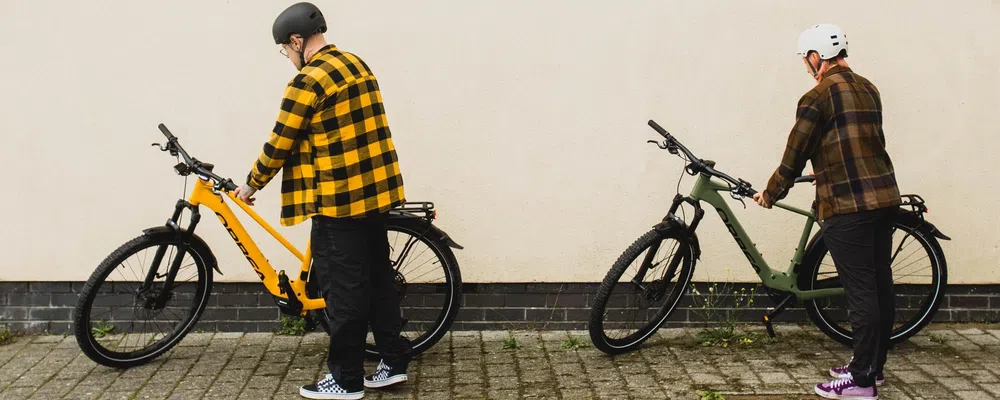 two cyclists parking their urban e-bikes wearing casual clothes