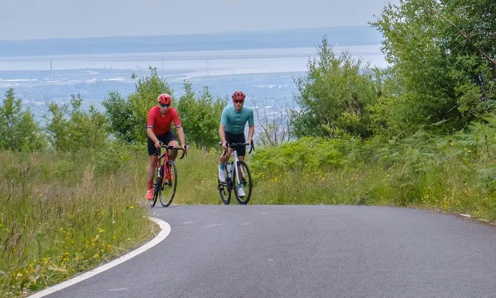 two road cyclists climbing out of the Welsh valleys on a warm summer day