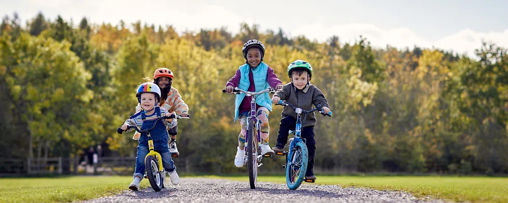 four kids riding bikes on a sunny autumn day