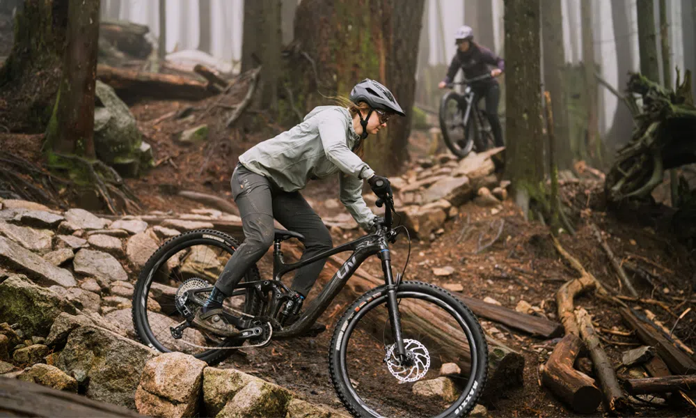 a women rides a liv mountain bike in the woods