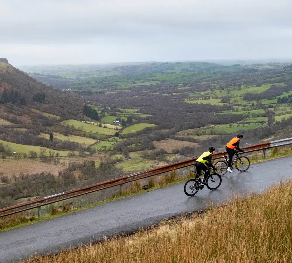 two cyclists climbing on a winter day in the welsh hills