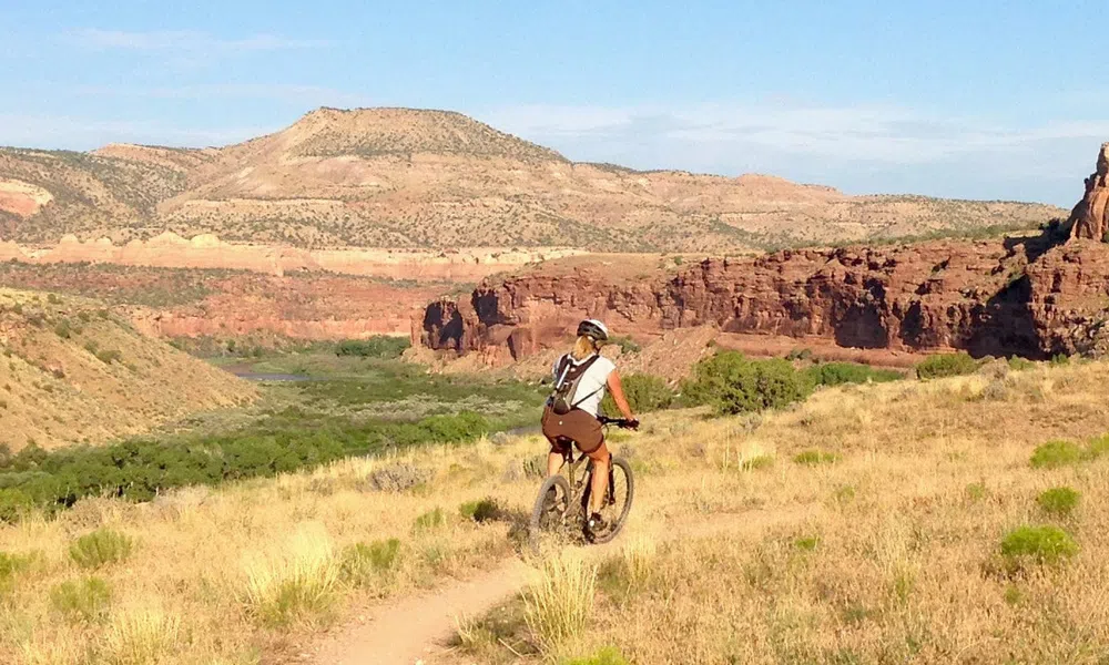 female mountain biker on dusty trail in the mountains