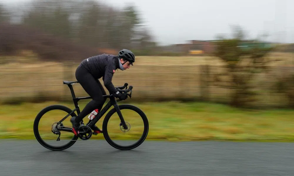 road cyclist riding fast on wet roads with Castelli rain gear