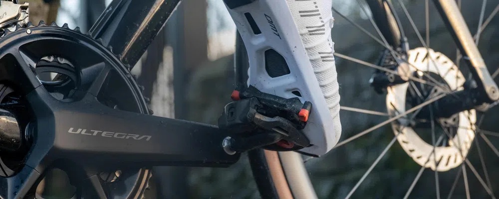 Cyclist clipping out of an SPD SL pedal wearing DMT cycling shoes