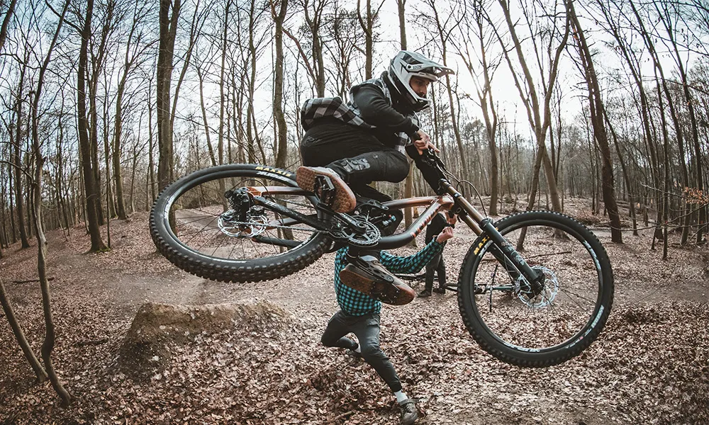 Nakidaii jumping on a NS downhill freeride bike in the woods