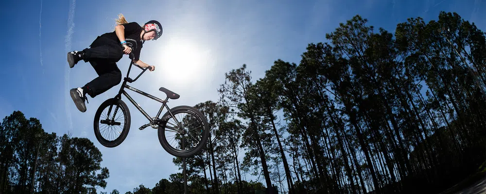 a female BMX rider does a tailwhip