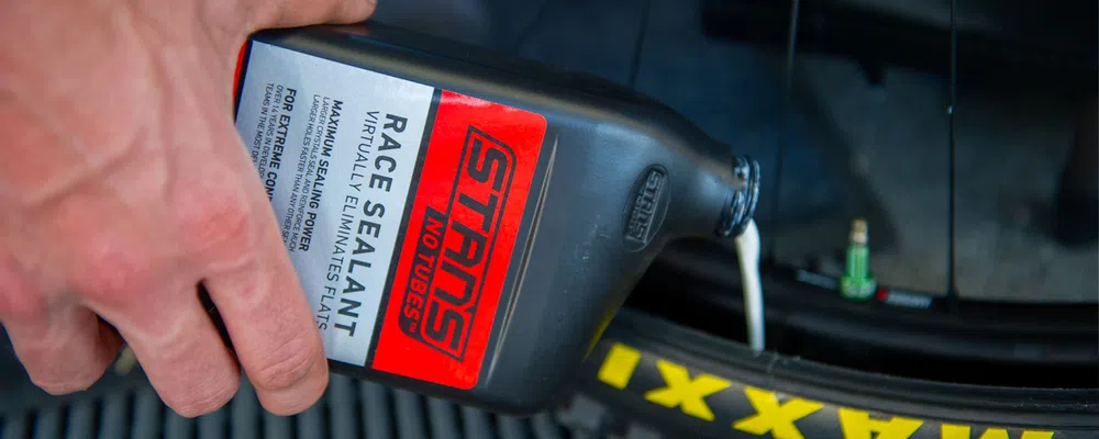 close up on tubeless sealant being poured into a tyre