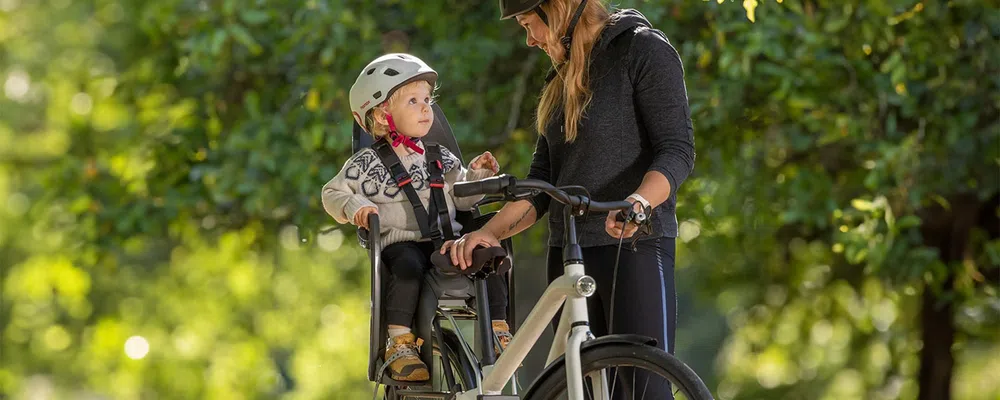 child on  a bike in a child seat looking at woman