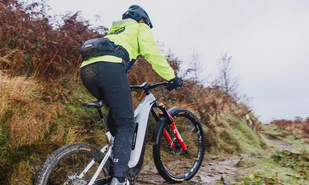 riding an emtb uphill wearing a waist pack