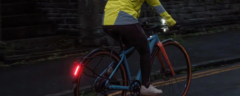 riding a bike with front and rear lights at night on the road