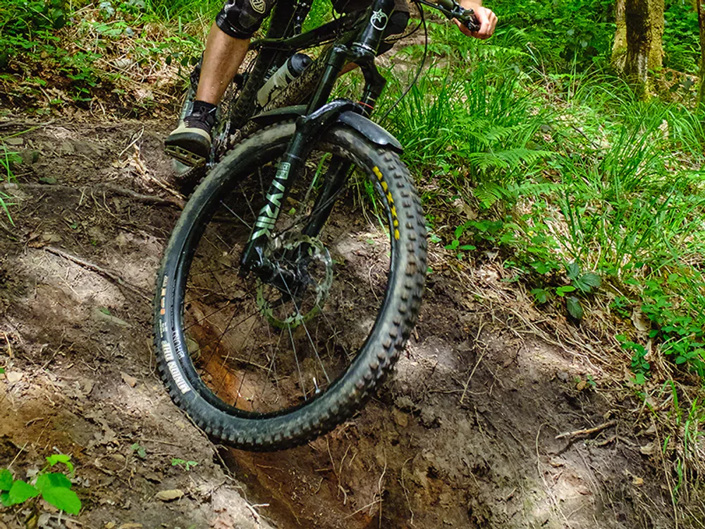 a mountain bike tyre rolls down steep terrain