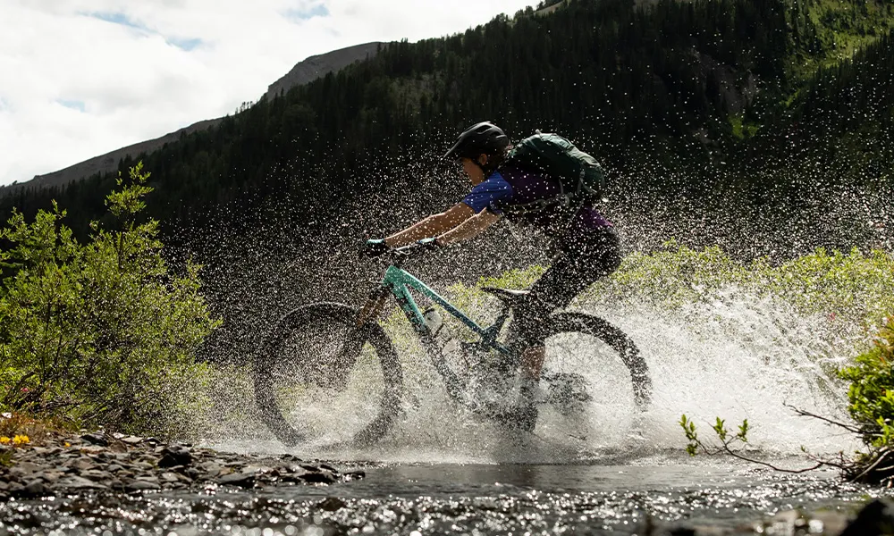 MTB rider splashing through a puddle on a Trek bike with Bontrager wheels