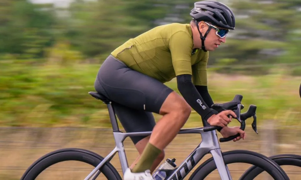 Man cycling on a performance road bike with arm warmers
