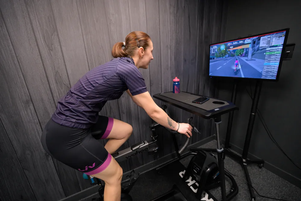 Female riding turbo trainer indoors