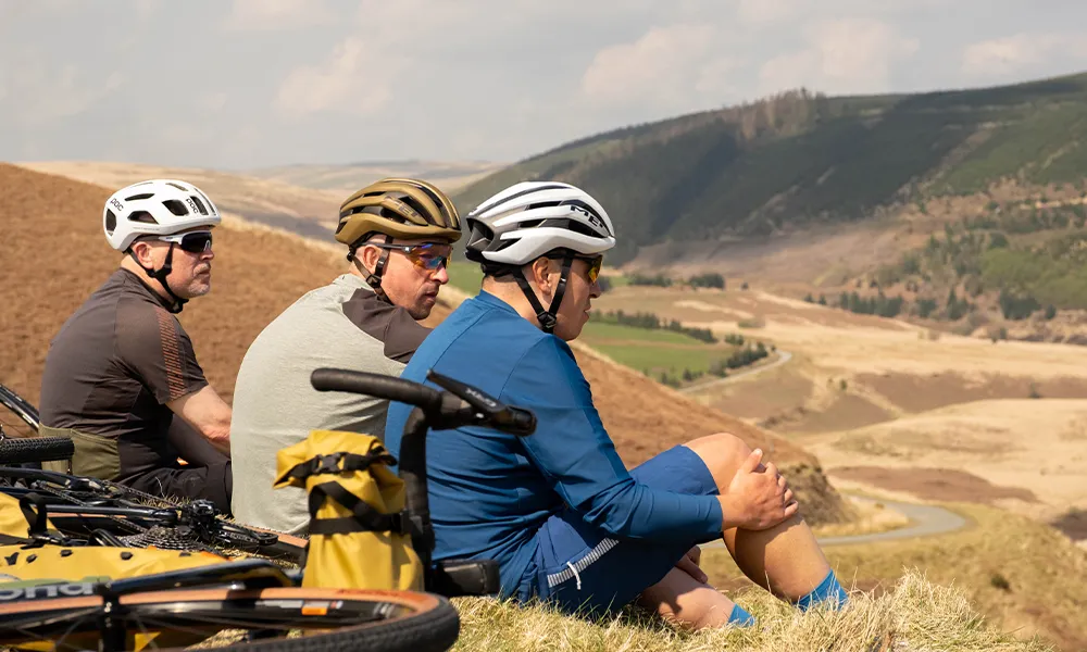 group of gravel riders chatting in bike helmets