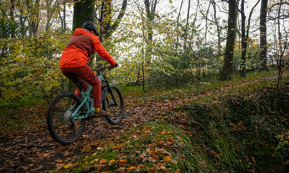 mtb rider cycling uphill on an e-bike wearing Endura trousers