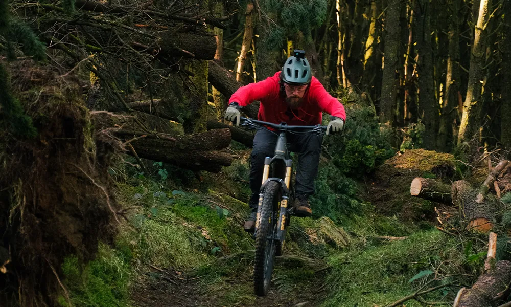 mountain biker riding a tech trail wearing a go pro helmet mount