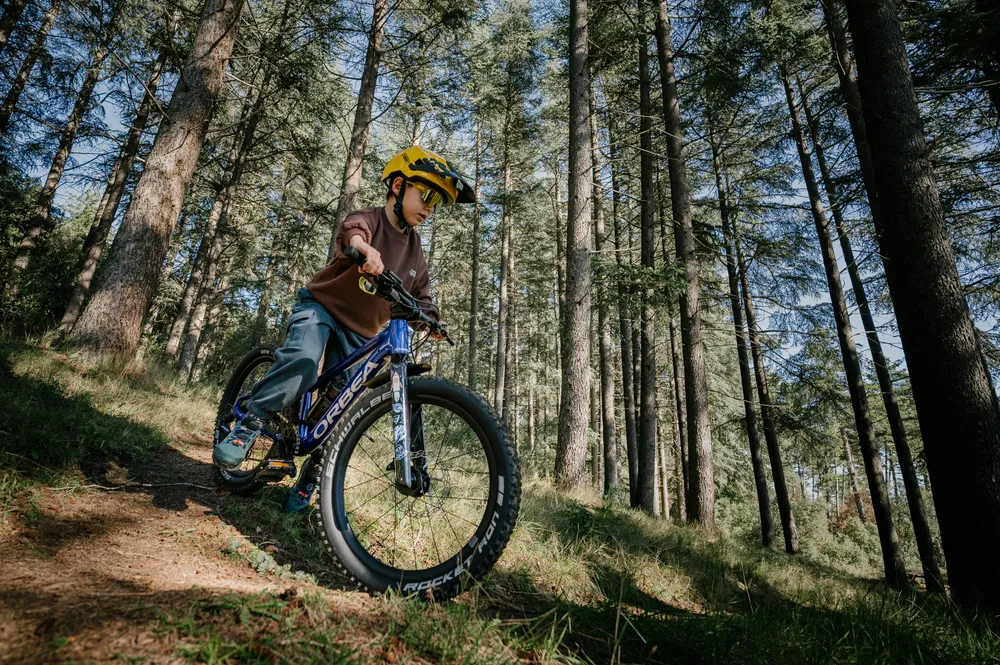 riding Orbea 20 inch bike in the woods